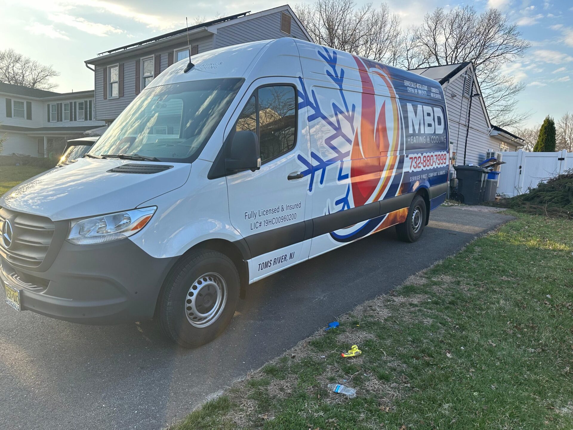 MBD Heating & Cooling service van parked outside a customer's home