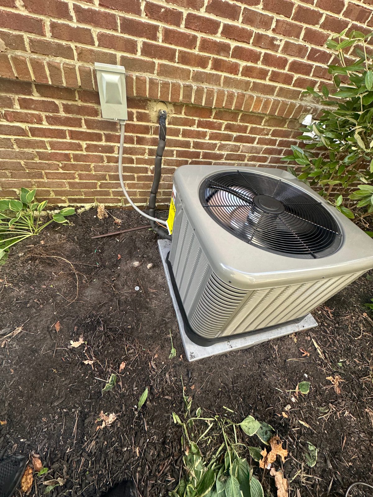 Outdoor condenser against a brick wall