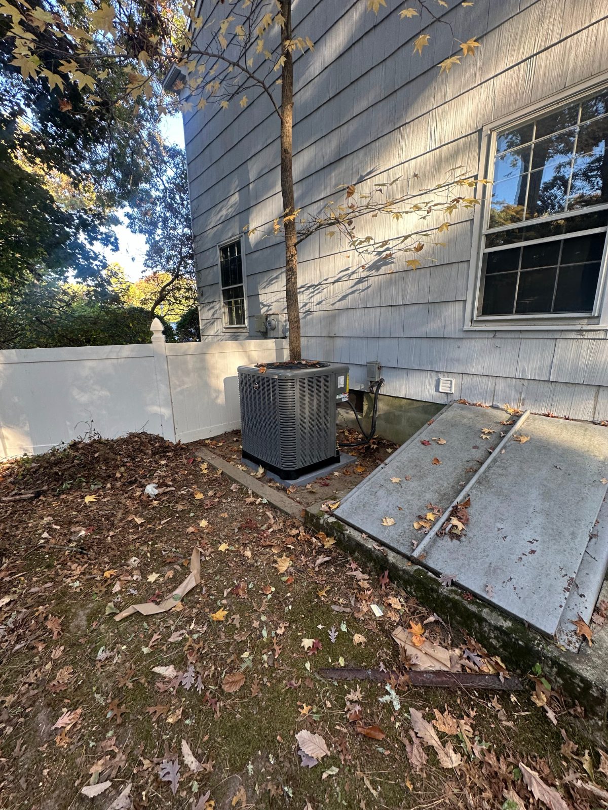 Outdoor condenser beside a shingled house