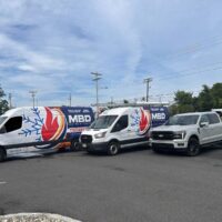 MBD Heating & Cooling service vans and pickup truck parked in Toms River, New Jersey