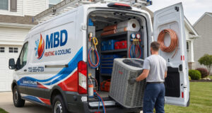 Technician unloading equipment from an MBD service van outside a home